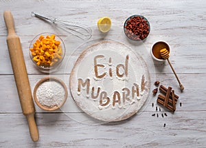 Eid Mubarak - Islamic holiday welcome phrase ` happy holiday`, greeting reserved. Arabic cuisine background.