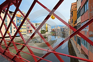 View of Girona through the bars of the Eiffel Bridge over the Onyar river, Catalonia, Spain photo