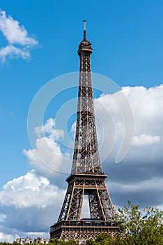 The Eiffel Tower against blue and cloudy sky, a wrought-iron lattice tower on the Champ de Mars in Paris, France, named after the