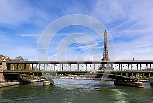 Eiffel Tower against blue sky with clouds and a bridge over Seine River. Paris France. April 2019