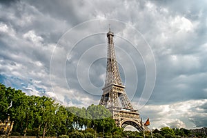 Eiffel Tower on cloudy sky in Paris, France. Architecture structure and design concept. Summer vacation in french capital