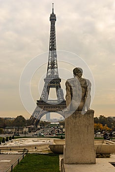 Eiffel Tower and The Man - L`Homme statue in Jardins de Trocadero during sunset in autumn, Paris, France