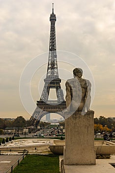 Eiffel Tower and The Man - L`Homme statue in Jardins de Trocadero during sunset in autumn, Paris, France photo