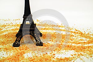 Eiffel tower miniature with breadcrumbs on a white background