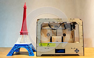 Eiffel Tower Model with Red White Blue Stripe printed by 3D Printer with 3D Printer on Wooden Table