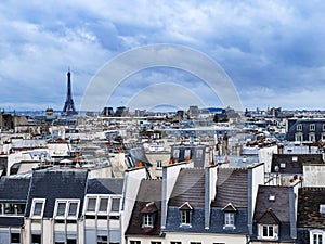 Eiffel tower over old Haussmann buildings roofs in Paris