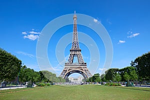 Eiffel Tower in Paris and empty green field of Mars meadow in a sunny day, clear blue sky