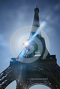 Eiffel Tower. Paris symbol and iconic landmark in France, on a bright sunny day with sunbeams in the sky.