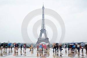 Eiffel tower in Paris with tourists and rain