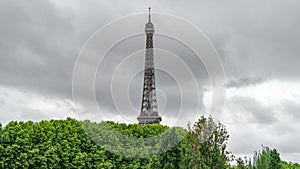 The Eiffel Tower rocket over the trees with stormy clouds