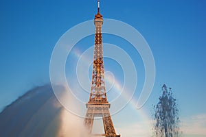 Eiffel Tower seen from fountain making natural rainbow, Paris, France