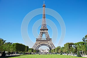 Eiffel tower, sunny summer day with blue sky and green grass