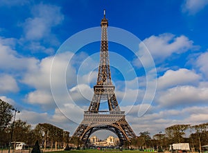 Eiffel Tower or Tour Eiffel seen from Champ de Mars in Paris, France on a beautiful cloudy day