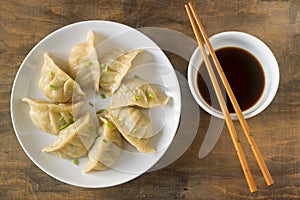 Eight boiled or fried jiaozi or gedza served with soy sauce. photo