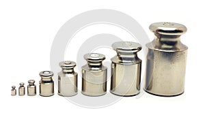 Eight calibration weights on white background photo