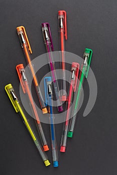 Eight colorful pens on black surface, mockup template