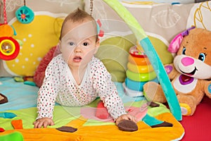Eight months old baby girl playing with colorful toys