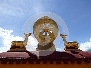 Eight-spoked Dharma wheel on lotus flower, flanked by a pair of deer on the roof of Jokhang Monastery, Lhasa, Tibet photo