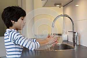 Eight year old boy washing hands