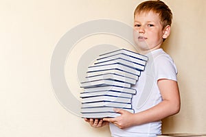 Eight-year-old child holds a stack of books