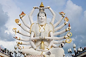 Eighteen arms Buddha over blue sky photo
