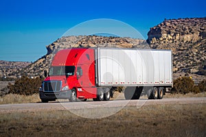 Eighteen wheel big rig tractor with trailer on highway. Trucking industry