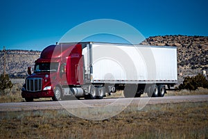 Eighteen wheel big rig tractor with trailer on highway. Trucking industry