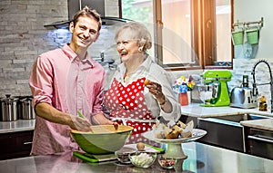 Grandmother baking cupcakes with her grandson