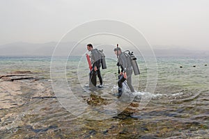 Eilat, Israel - May 2018: School of divers. Two divers go out of the sea