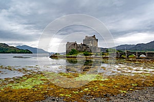 Eilean Donan Castle Partly Reflecting in Loch Duich with Bridge and Seaweed