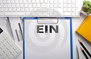 EIN - Employer Identification Number written on paper with keyboard, chart, calculator and notebook