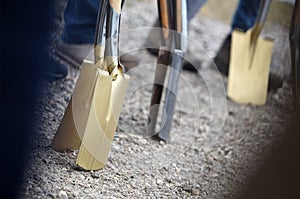 A golden spade at a groundbreaking ceremony for a building photo