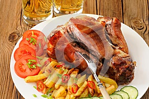 Eisbein or pork knuckle with french fries and vegetables