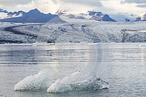 Eisberg in lagoon with glacier background, Iceland photo