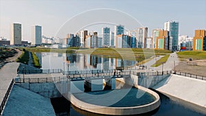 Ekaterinburg, Russia, a pond with a bridge in a new park. Video. Aerial view of a beautiful city district with colorful