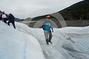 A mountain guide helps ice trekking tourists on Perito Moreno Glacier in the Los Glaciares National Park