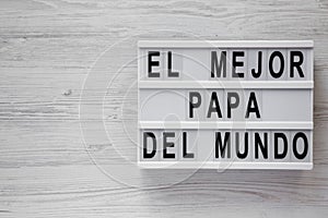 `El Mejor Papa Del Mundo` words on a modern board over white wooden background, top view. Overhead, from above, flat lay. Father photo