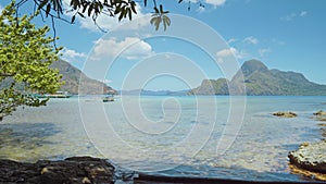 El Nido bay with banca boats floating on water surface with white clouds above. Palawan, Philippines