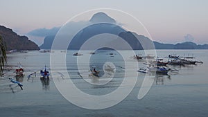 El Nido bay in beautiful morning light. Banca boats in calm lagoon rippled surface. Palawan Island. Philippines