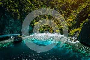 El Nido, Palawan, Philippines, aerial view of banca boat, karst mountain wall pristine sand beach and coral reef, great