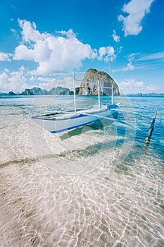 El Nido, Palawan, Philippines. Banca boat on sandy beach in shallow crystal clear water on island hopping trip. Amazing