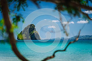 El Nido, Palawan, Philippines Journey. Tropical beach scenery with rocky island in open ocean framed thought some