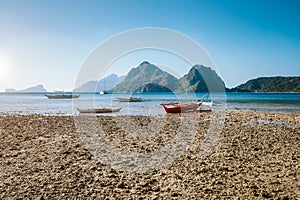 El Nido, Palawan,Philippines. Local fishing boats during low tide at Las Cabanas Beach with amazing mountains in background