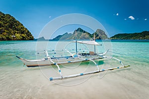 El Nido, Palawan, Philippines. Local tourist banca boat for island hopping trip. Beautiful mountains in background