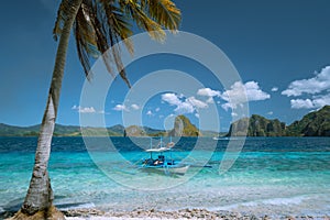 El Nido, Palawan, Philippines. Lonely filippino banca boat moored in turquoise ocean water. Island hopping tour with