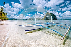 El Nido, Palawan, Philippines. Tropical scenery of banca boat on the sandy beach ready for island hopping tour