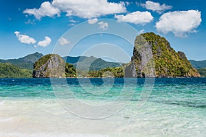 El Nido, Philippines. Crystal clear blue water lagoon and private Malapacao island in background