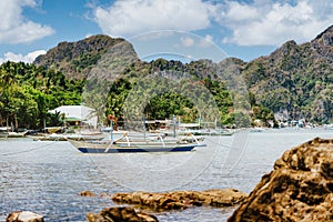 El Nido village and mountains, Palawan, Philippines. Bangka fishing in the bay shallow water