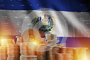 El Salvador flag and big amount of golden bitcoin coins and trading platform chart. Crypto currency photo