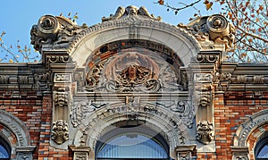 Elaborate stonework depicting classical ornaments, with a central mascaron above a grand arch window. Generate AI